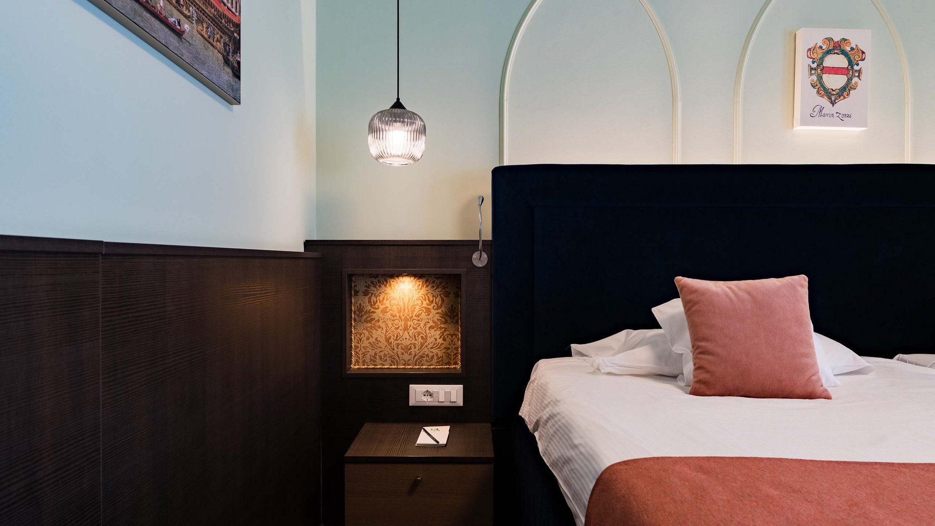 Hotel vicino a Venezia con terme: servizi inclusi Camera da letto con testiera nera, cuscino rosa e illuminazione soffusa