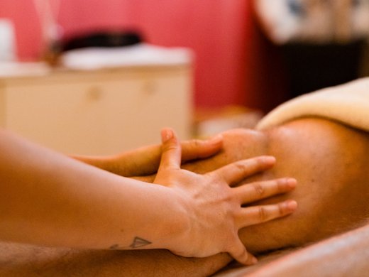 Hotel termale a Montegrotto: viaggio della salute Mano che massaggia una gamba in un ambiente rilassante