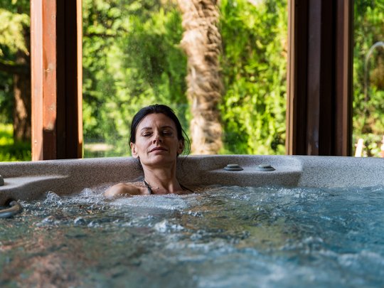 Hotel in Montegrotto Terme: the Garden Terme Woman relaxing in indoor hot tub with green outdoor view