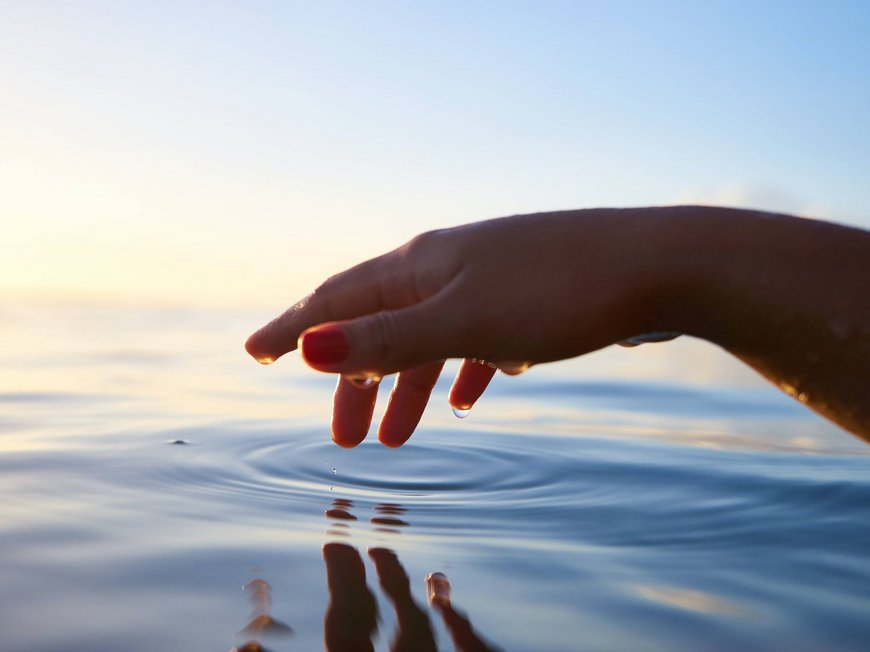Hotel a 4 stelle vicino ad Abano Terme: workshop e seminari Mano che sfiora l'acqua calma con riflessi al tramonto